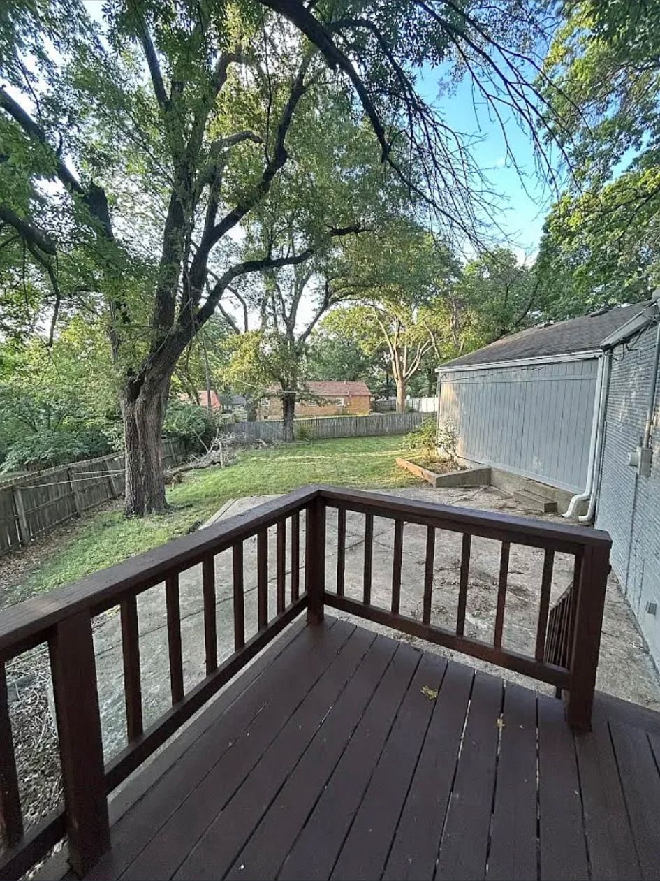 Back deck looking over the fenced backyard and mature trees