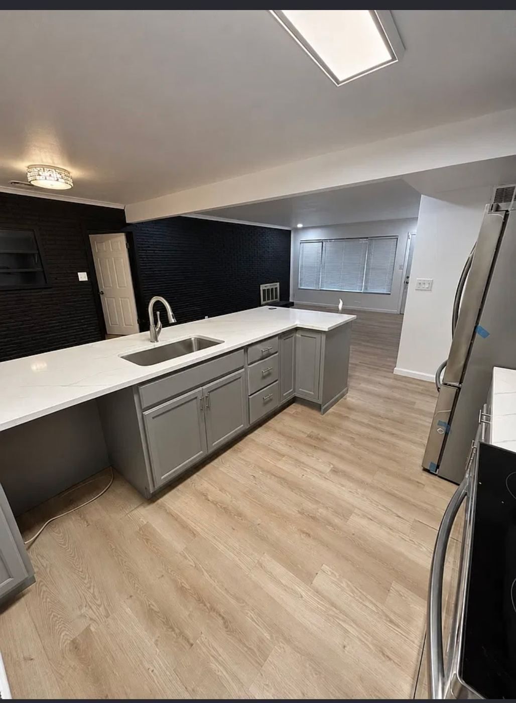 Remodeled kitchen with white quartz counters and gray cabinets
