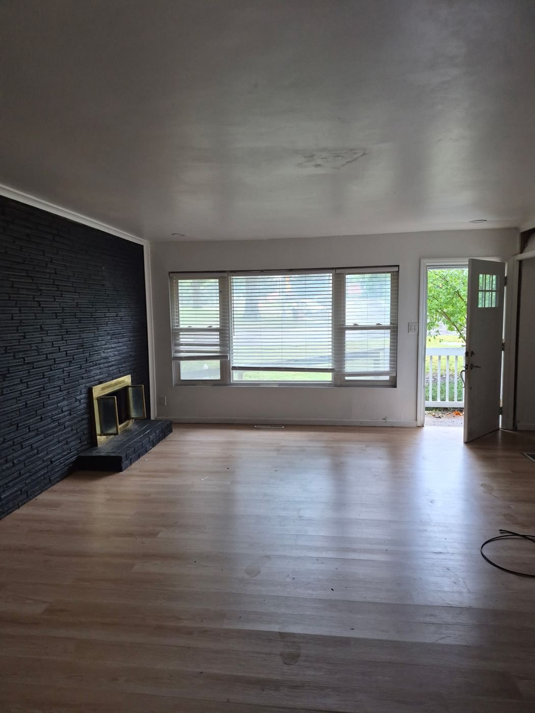 Living room with a stone fireplace and large front windows